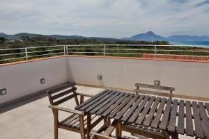 a balcony with a wooden bench and a table at casa verdemare in Cefalù