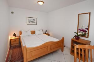 a bedroom with a wooden bed and a mirror at Apartments Marija in Poreč