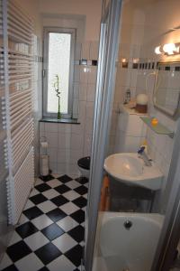 a bathroom with a black and white checkered floor at Messewohnung Augusta in Wuppertal