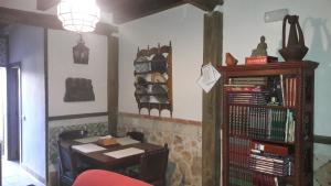 uma sala de jantar com uma mesa e uma estante de livros em El Templete de San Miguel em San Miguel de Bernúy