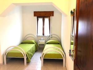 2 camas en una habitación pequeña con ventana en Apartment Maria en Tergu