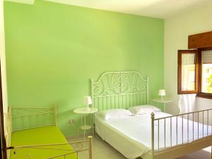 1 dormitorio con cama y pared verde en Apartment Maria en Tergu
