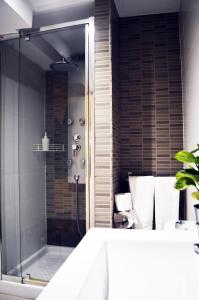 une salle de bain avec une douche avec une porte vitrée dans l'établissement Barcelona Mercaders Apartments, à Barcelone