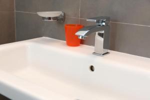 a bathroom sink with a faucet and a red cup at casa verdemare in Cefalù