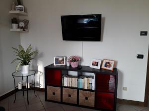uma prateleira de livros pretos com uma televisão na parede em IEO - HUMANITAS - MILANO CENTRO a 15 minuti em Locate di Triulzi