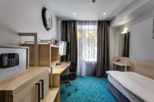 ein Hotelzimmer mit einem Bett und einem Schreibtisch in der Unterkunft Marins Park Hotel Rostov in Rostow am Don
