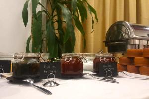 una mesa con tres tarros de miel y cucharas en Agnantio Hotel & Spa, en Sidirókastro