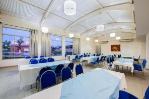 a conference room with tables and chairs and windows at GOLD MARTAN HOTEL in Belém