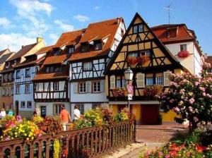 een groep gebouwen in een stad met bloemen bij Chez Fretz in Ribeauvillé