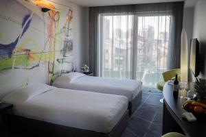 a hotel room with two beds and a window at Golden Tulip Zira Belgrade in Belgrade