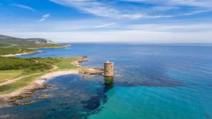 an island in the ocean with a tower in the water at La Marine in Luri +28 photos