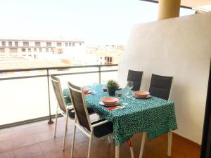 a dining room table with chairs and a view of a city at BEACH & SUN MONCOFA in Moncófar