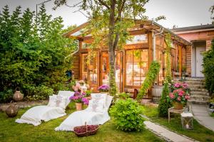 einen Garten mit drei weißen Stühlen und ein Haus in der Unterkunft Weißt Du noch - Gästehäuser & Suiten in Kühlungsborn