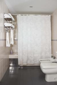 a bathroom with a toilet and a shower curtain at Hosteria Solar de la Costa in Puerto Madryn