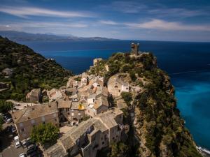 an aerial view of a village on a mountain with the ocean at La Marine in Luri