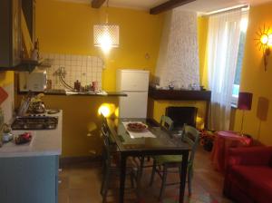 a kitchen with a table and a kitchen with yellow walls at Nel verde house di Rolando in Turin