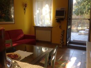 sala de estar con mesa de cristal y sofá rojo en Nel verde house di Rolando en Turín