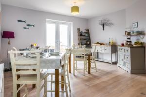 a kitchen with a table and chairs in a room at An Cois Na Mara Bed & Breakfast in Laide