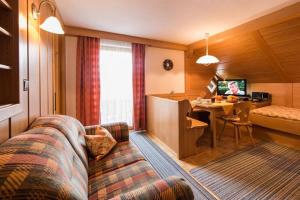 a hotel room with a couch and a desk in a room at Landhaus Beßler in Bad Hindelang