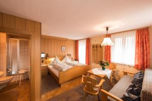 a hotel room with a bed and a table at Landhaus Beßler in Bad Hindelang