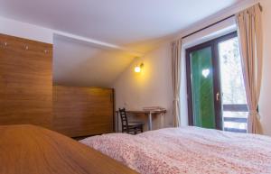 a bedroom with a bed and a window and a table at Charming Chalet Timisu de Sus in Predeal