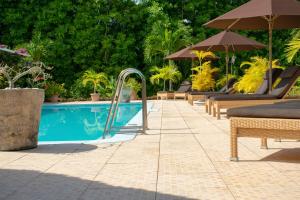 a swimming pool with chairs and umbrellas next to a pool at Villa De Cerf in Cerf Island