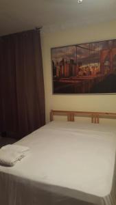 a bed in a room with a painting on the wall at TERRAZAS DEL CARIBE, APARTA HOTEL. in Santo Domingo +27 photos
