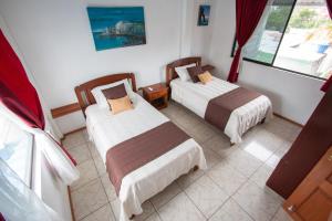 a bedroom with two beds and a window at Maytenus Galapagos in Puerto Ayora