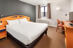 a bedroom with a bed and a desk at ibis Chesterfield North - Barlborough in Barlborough