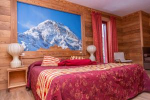 sypialnia z dużym obrazem pokrytej śniegiem góry w obiekcie Hotel Chaberton w mieście Cesana Torinese