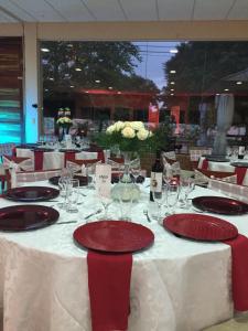 una mesa con platos rojos y copas de vino. en HOTEL BOUTIQUE EL RANCHO OLIVO, en Villamontes 162 fotos más