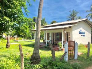 una piccola casa con una recinzione di fronte di Sai Seashell Rest Inn Nilaveli a Trincomalee