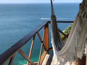 un balcón con hamaca y vistas al océano en Bangalô dos Sonhos, en Morro de São Paulo