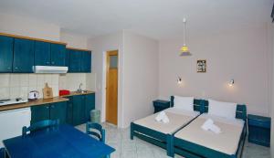 Zimmer mit einem Bett und einer Küche mit blauen Schränken in der Unterkunft Athanasia Studios in Patitiri
