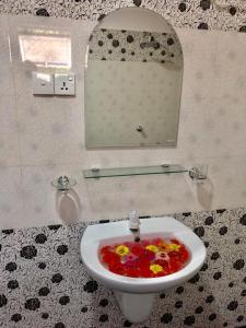 La salle de bains est pourvue d'un lavabo avec un liquide coloré. dans l'établissement Sai Seashell Rest Inn Nilaveli, à Trincomalee