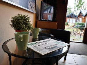 einen Tisch mit einer Zeitung und zwei Tassen drauf. in der Unterkunft Motel Oostvoorne in Oostvoorne