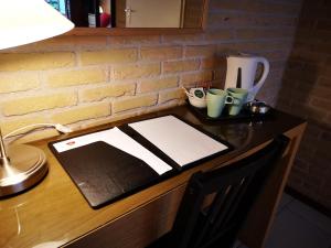 einen Schreibtisch mit einem Papier auf einem Tisch mit einer Lampe in der Unterkunft Motel Oostvoorne in Oostvoorne