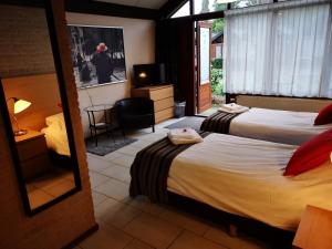 a hotel room with two beds and a mirror at Motel Oostvoorne in Oostvoorne