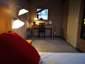 - une chambre avec un lit et un bureau avec une table dans l'établissement Motel Oostvoorne, à Oostvoorne