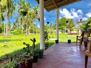 un portico con palme e un prato di Sai Seashell Rest Inn Nilaveli a Trincomalee