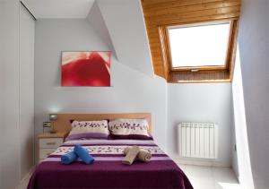 ハカにあるApartamento Jacaのベッドルーム1室(紫のシーツが敷かれたベッド1台、窓付)