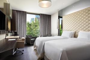a hotel room with two beds and a desk at Excelsior Hotel Gallia, a Luxury Collection Hotel, Milan in Milan