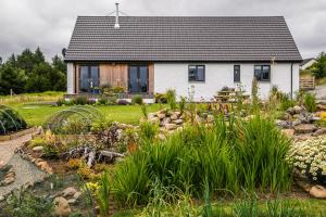 una casa con un jardín delante de ella en An Cois Na Mara Bed & Breakfast, en Laide