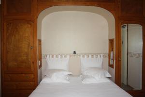 a bedroom with a bed with white sheets and pillows at La Marjolaine in Juan-les-Pins