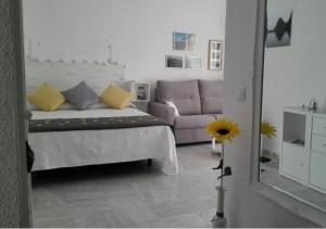 トレモリノスにあるCoqueto estudio Montemarのベッドルーム(ベッド1台、ソファ、鏡付)