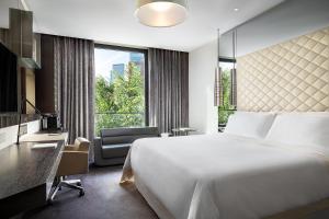ein Hotelzimmer mit einem großen Bett und einem Schreibtisch in der Unterkunft Excelsior Hotel Gallia, a Luxury Collection Hotel, Milan in Mailand