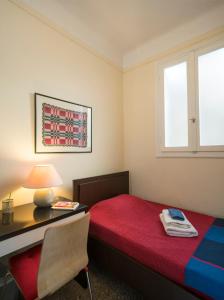 a bedroom with a red bed and a desk and a window at ACROPOLIS MUSEUM APARTMENT in Athens