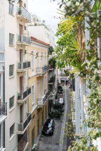 une rue d'appartements dans une ville avec des voitures garées dans la rue dans l'établissement ULTIMATE LOCATION CENTRAL ATHENS, à Athènes