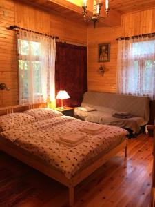 a bedroom with a bed in a wooden cabin at Siedlisko Nasza Chata in Popiołki