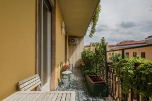 un balcón con 2 bancos, una mesa y flores en Casa di Gioia, en Verona